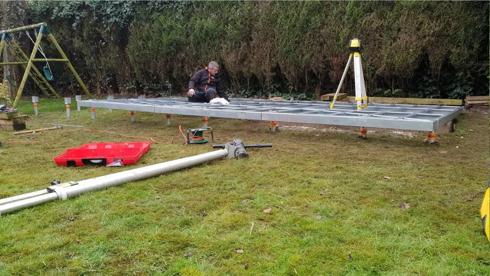 Steel foundation frame being fixed to installed ground screws