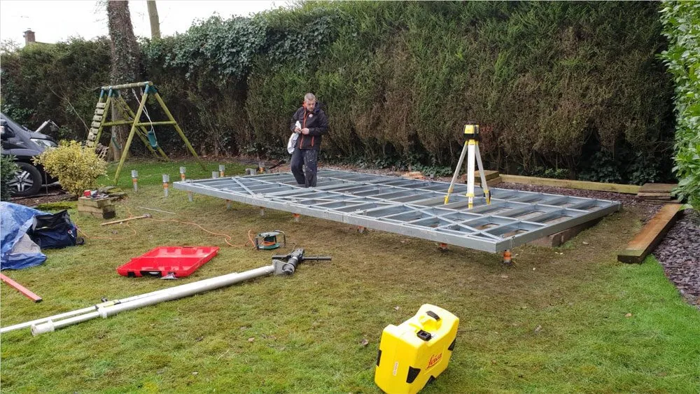 Ground screw foundation frame being levelled on a no dig foundation install