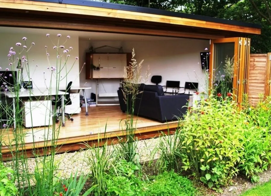 Timber clad garden room with bi-fold doors on a screw pile base